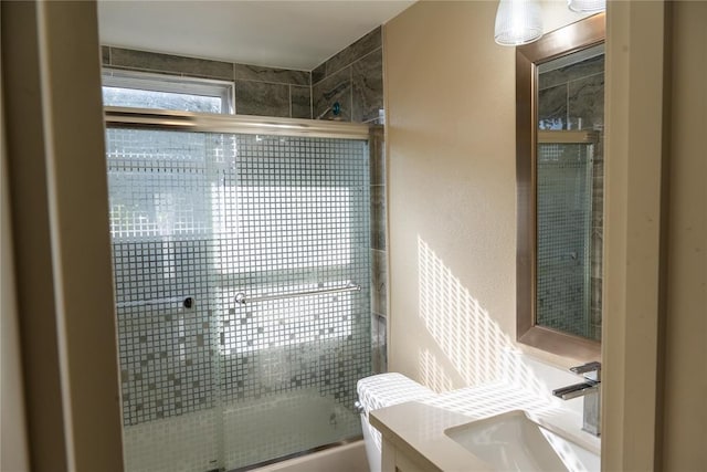 bathroom featuring combined bath / shower with glass door and vanity