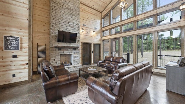 living room with wooden walls, high vaulted ceiling, wooden ceiling, a fireplace, and a chandelier