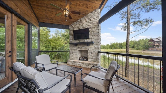 wooden terrace featuring an outdoor stone fireplace and ceiling fan