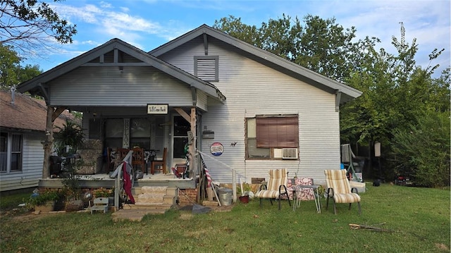 back of house featuring a lawn and a porch