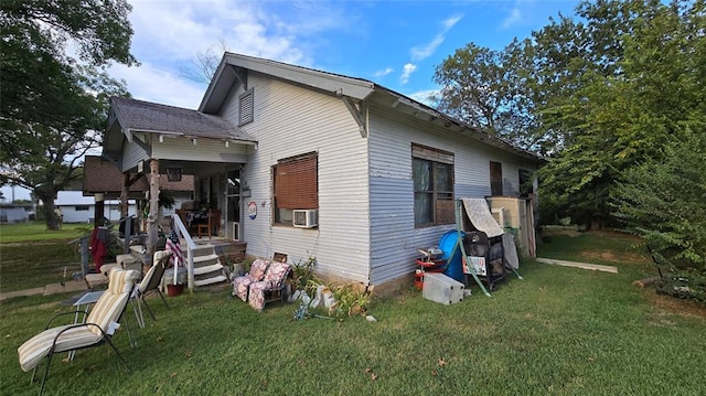 view of side of home with cooling unit and a lawn