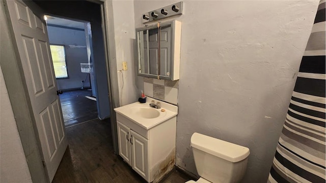 618 S Wewoka Ave, Wewoka, OK 74884 - bathroom featuring toilet, vanity, and hardwood / wood-style flooring