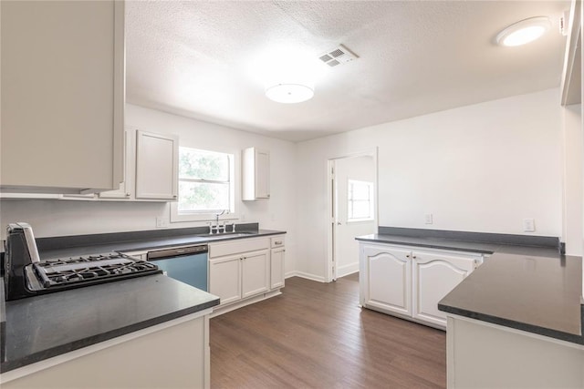 kitchen featuring dishwasher, white cabinets, sink, dark hardwood / wood-style flooring, and range