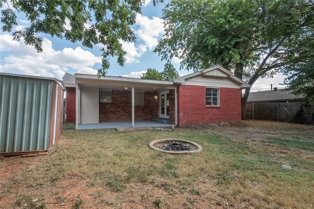 rear view of house with a lawn and a patio