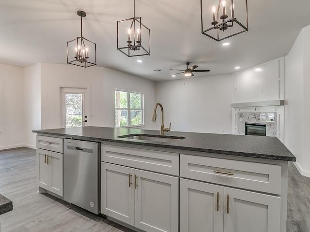 kitchen with light wood-type flooring, ceiling fan, sink, decorative light fixtures, and dishwasher