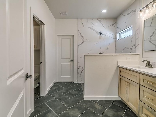 bathroom with tile patterned floors, walk in shower, vanity, and toilet