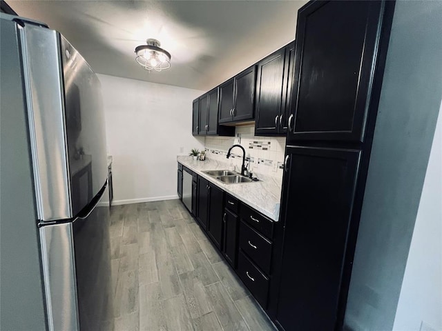 kitchen with decorative backsplash, stainless steel appliances, light hardwood / wood-style floors, and sink