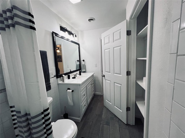 bathroom with hardwood / wood-style floors, vanity, and toilet