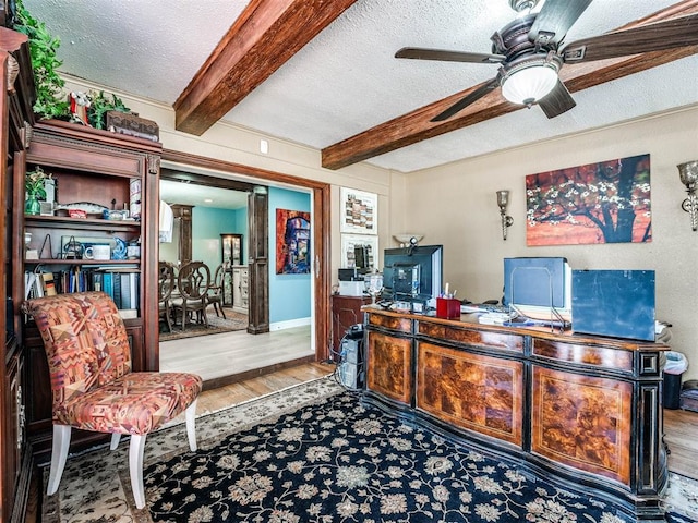 office space featuring hardwood / wood-style flooring, ceiling fan, a textured ceiling, and beamed ceiling