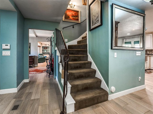 stairs featuring hardwood / wood-style floors