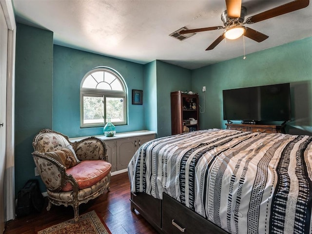 bedroom with dark hardwood / wood-style flooring and ceiling fan