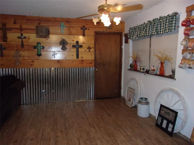 living room featuring ceiling fan, a textured ceiling, and hardwood / wood-style flooring