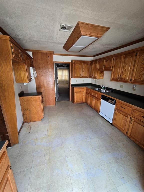 kitchen with a textured ceiling, white appliances, and sink