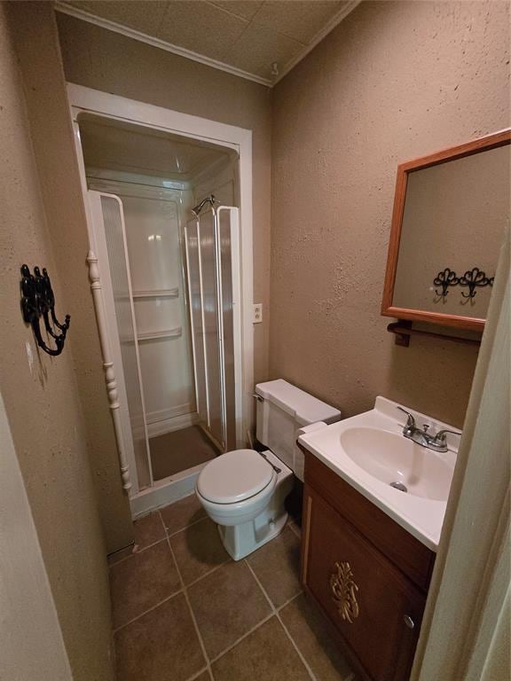 bathroom featuring walk in shower, tile patterned floors, toilet, vanity, and ornamental molding