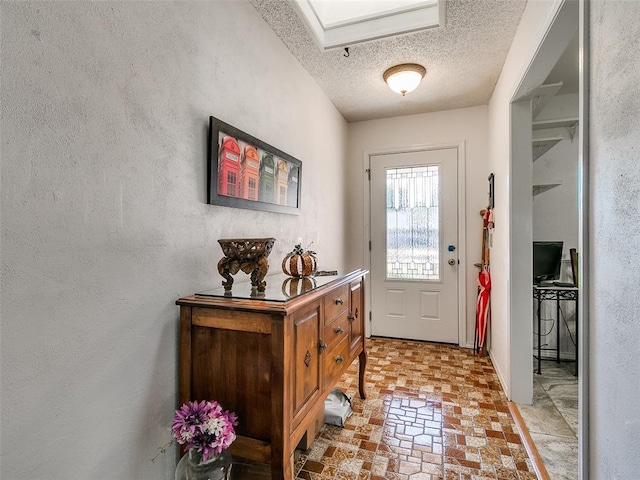 doorway to outside featuring a textured ceiling