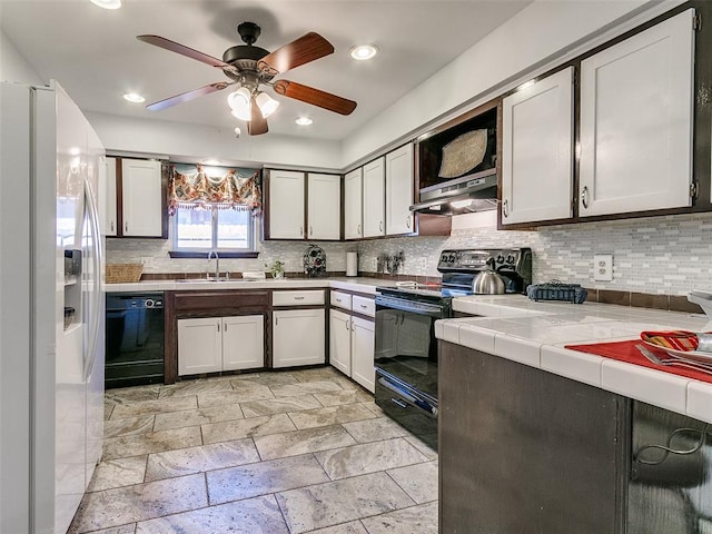 kitchen with ceiling fan, sink, tile countertops, white cabinets, and black appliances