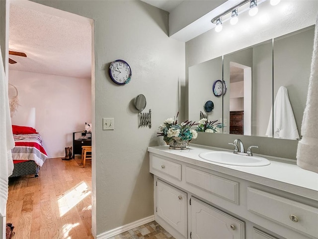 bathroom with hardwood / wood-style floors, vanity, a textured ceiling, and ceiling fan