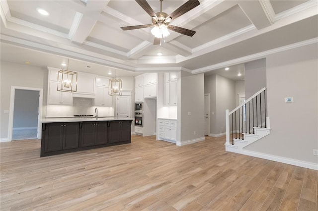 kitchen featuring coffered ceiling, a sink, white cabinets, light countertops, and light wood-type flooring