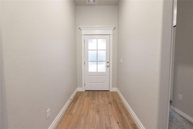 doorway featuring visible vents, light wood finished floors, and baseboards