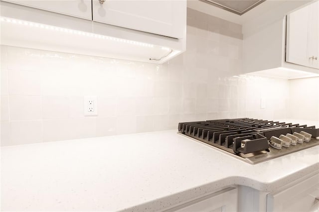 14109 Birch Ln, Edmond, OK 73049 - details with tasteful backsplash, stainless steel gas cooktop, and white cabinetry