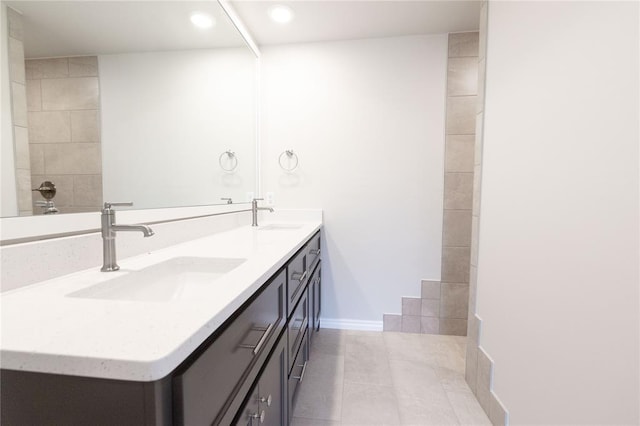 14109 Birch Ln, Edmond, OK 73049 - bathroom featuring tile patterned floors, double vanity, a sink, and baseboards