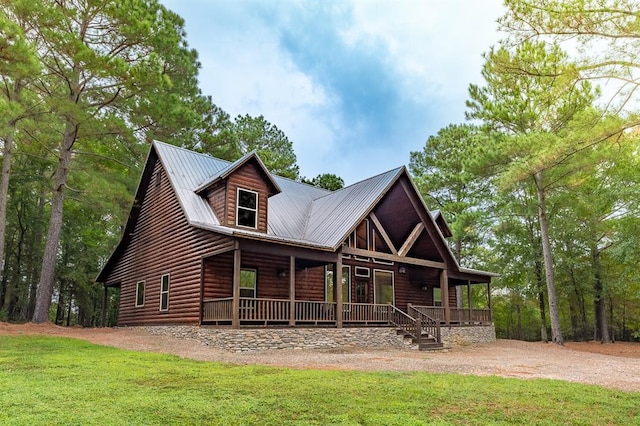 cabin featuring a porch and a front lawn