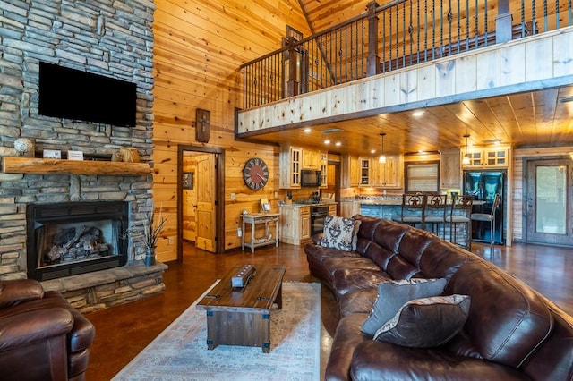 living room with a stone fireplace, high vaulted ceiling, wood walls, and wood ceiling