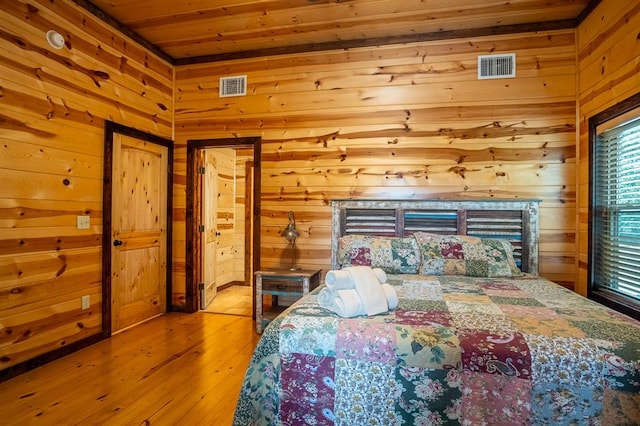 bedroom featuring wooden ceiling, wooden walls, and light hardwood / wood-style flooring