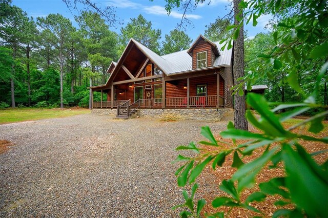 143 Honey Crisp Ln, Broken Bow, OK 74728 - view of front of property with log veneer siding, covered porch, metal roof, and driveway