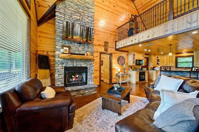 143 Honey Crisp Ln, Broken Bow, OK 74728 - living room with wooden walls, a stone fireplace, a high ceiling, dark wood-type flooring, and wooden ceiling