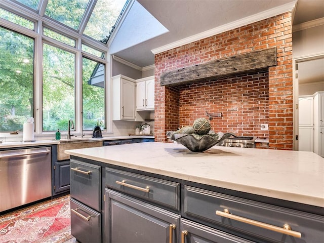 kitchen featuring dishwasher, a skylight, ornamental molding, light stone counters, and white cabinetry