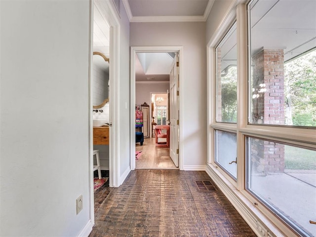 hallway with dark hardwood / wood-style floors and crown molding