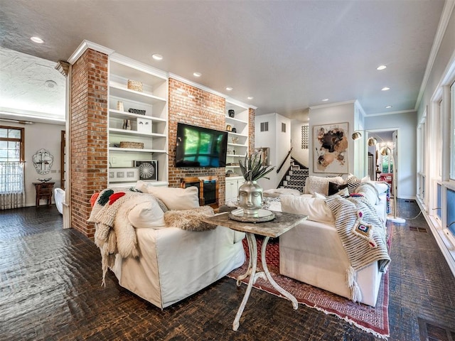 living room featuring a fireplace, built in shelves, a textured ceiling, and ornamental molding