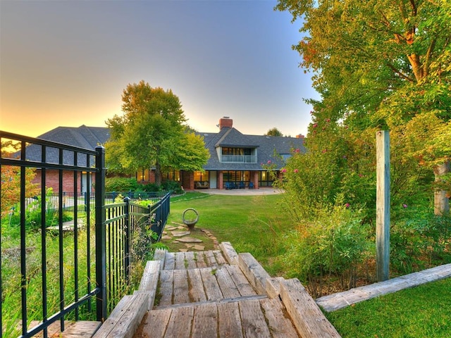 yard at dusk featuring a patio area and fence