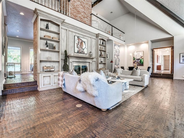 living room with beamed ceiling, built in shelves, ornamental molding, and high vaulted ceiling