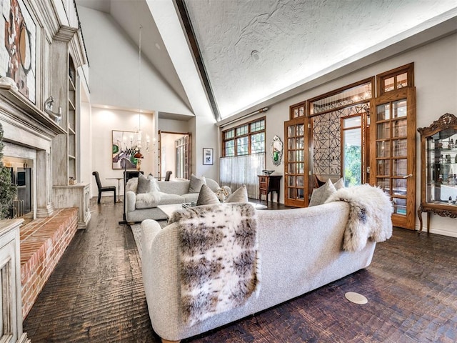 living room with built in shelves, a textured ceiling, high vaulted ceiling, and a brick fireplace