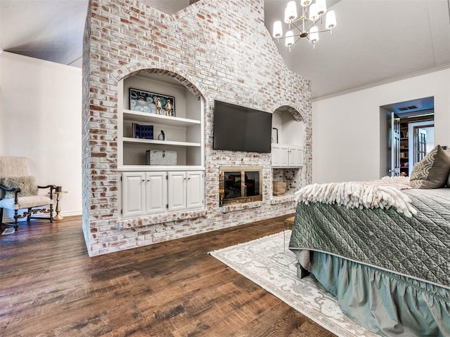 bedroom featuring ornamental molding, a chandelier, a fireplace, a high ceiling, and dark hardwood / wood-style floors