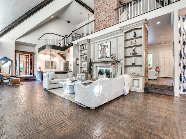 living area with a high end fireplace, plenty of natural light, and a towering ceiling