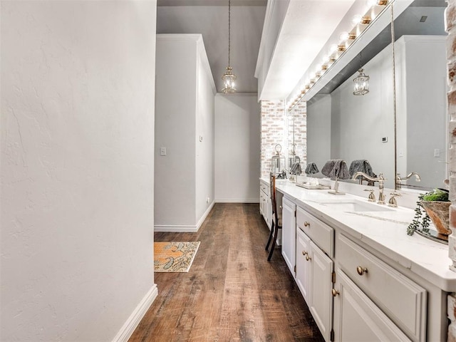 bathroom featuring vanity, baseboards, and wood finished floors