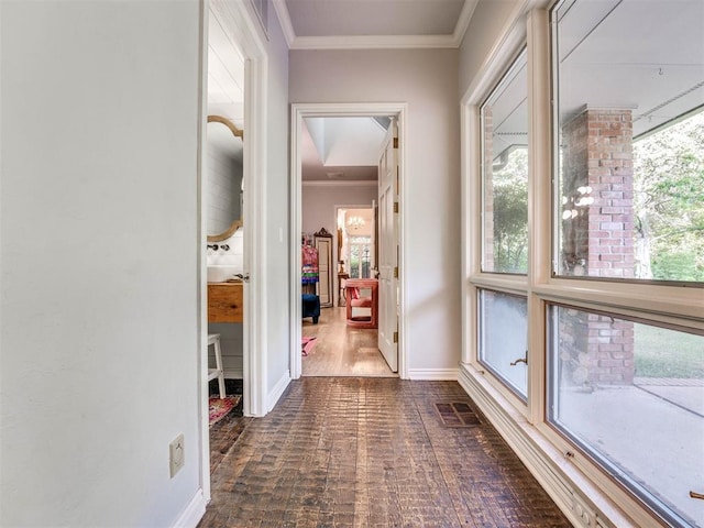 corridor with ornamental molding, visible vents, and baseboards