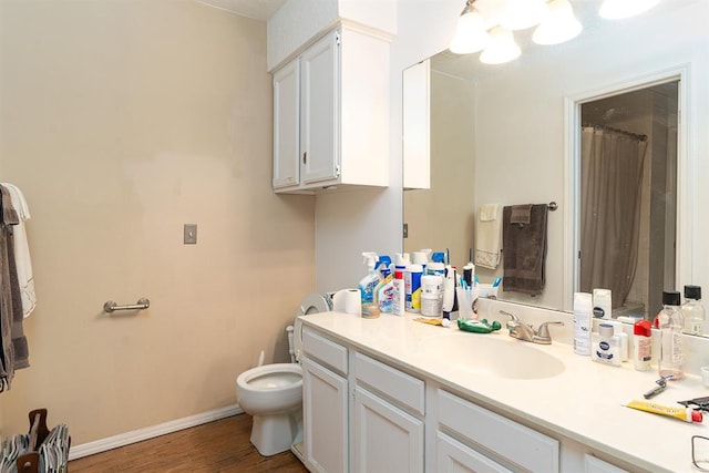 bathroom with hardwood / wood-style floors, vanity, and toilet