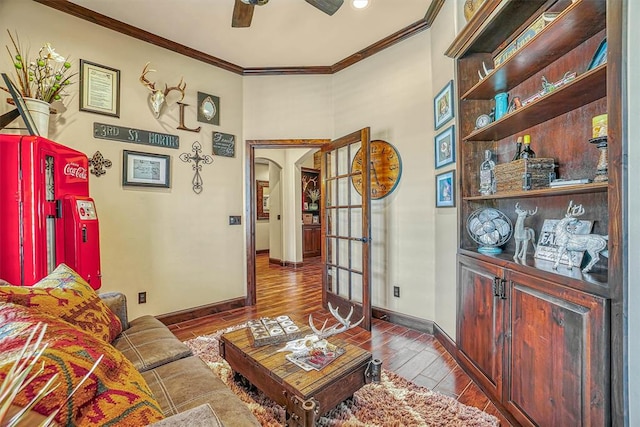 living room featuring ceiling fan, wood-type flooring, and crown molding