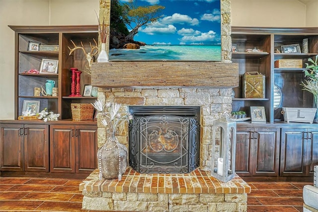 room details featuring wood-type flooring and a stone fireplace