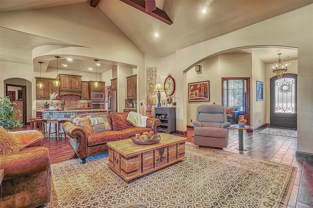 living room with beam ceiling, wood-type flooring, high vaulted ceiling, and a chandelier