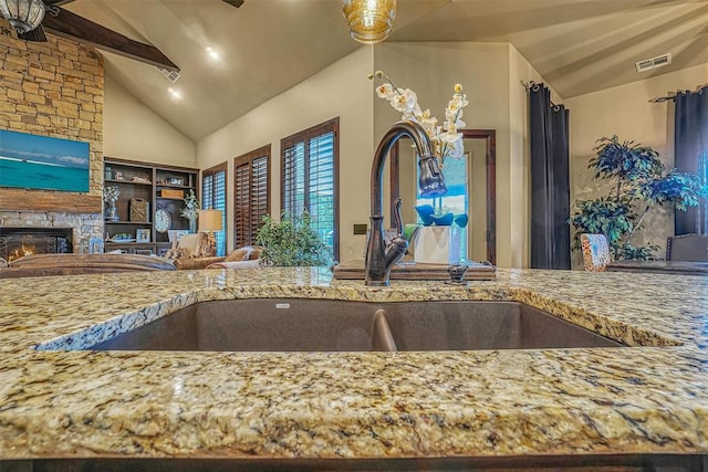 kitchen featuring a fireplace, lofted ceiling, and sink