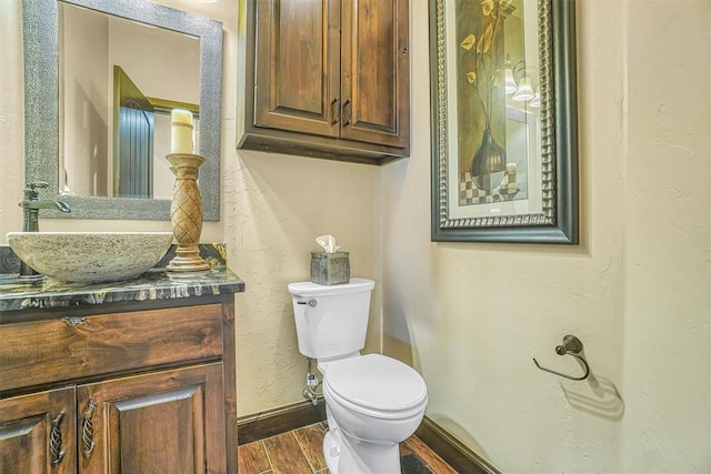 bathroom featuring wood-type flooring, vanity, and toilet