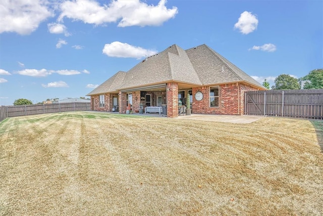 rear view of house featuring a patio area and a yard