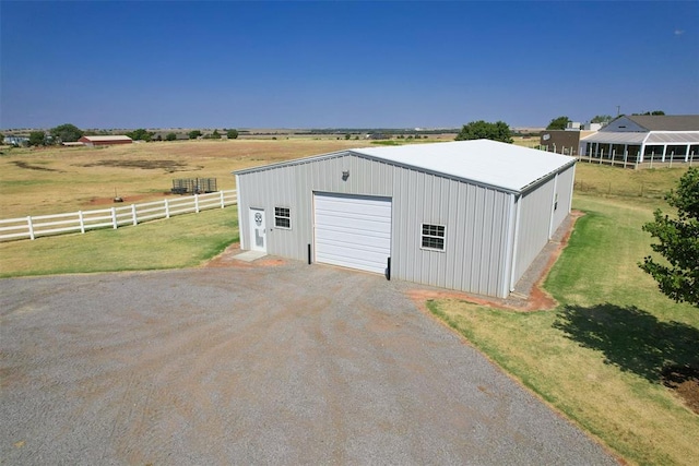 view of outdoor structure featuring a yard, a rural view, and a garage