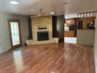 1305 SE 15th St, Wagoner, OK 74467 - unfurnished living room with wood finished floors and a fireplace