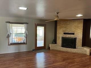 1305 SE 15th St, Wagoner, OK 74467 - unfurnished living room featuring wood finished floors, a brick fireplace, and ceiling fan